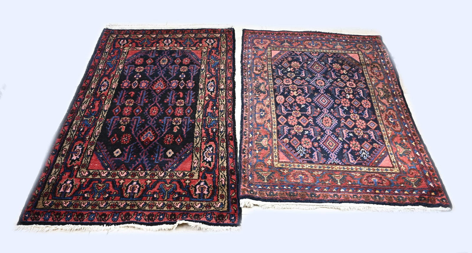 2x Persian carpet: 2x Persian rug: 1x Red/black with blue floral motif, size: 170 x 105 cm. 1x Red with dark blue floral motif, size: 155 x 110 cm. In good condition.