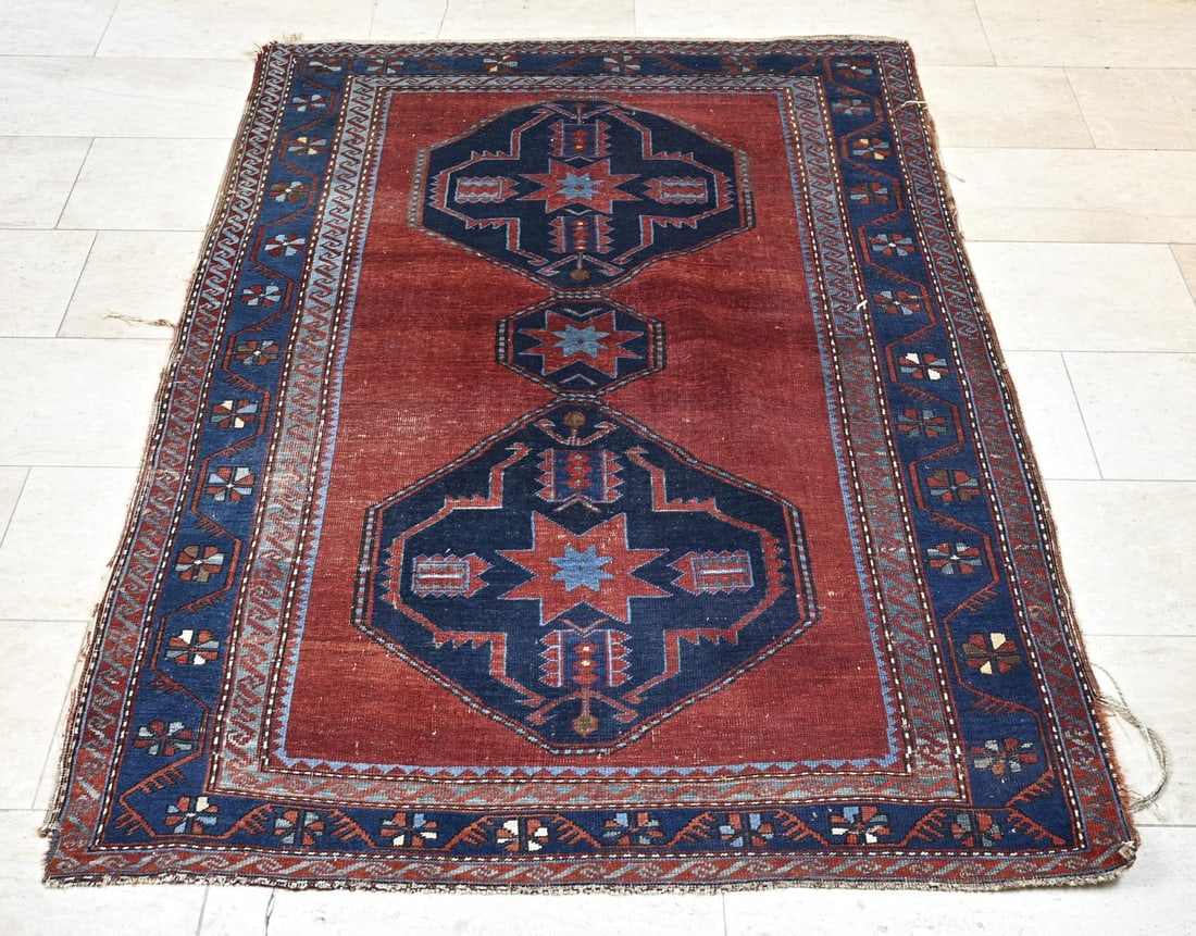 Persian carpet, 202 x 148 cm.: Hand-knotted Persian carpet. Red with blue border and medallion. Edges slightly loose. Dimensions: 202 x 148 cm. In reasonable condition.