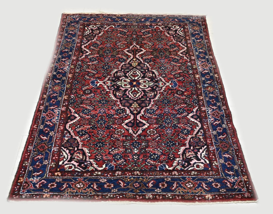Persian rug, 202 x 138 cm.: Hand-knotted Persian rug. Colour: red with blue, with a flower medallion in the middle. Dimensions: 202 x 138 cm. In good condition.