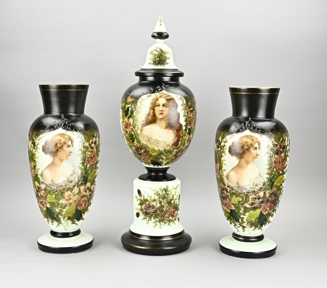 Opaline glass cabinet set, H 46 - 62 cm.: Three-piece opaline glass cabinet set with floral relief decoration, gold and ladies portraits. Dimensions: H 46 - 62 cm. In good condition.