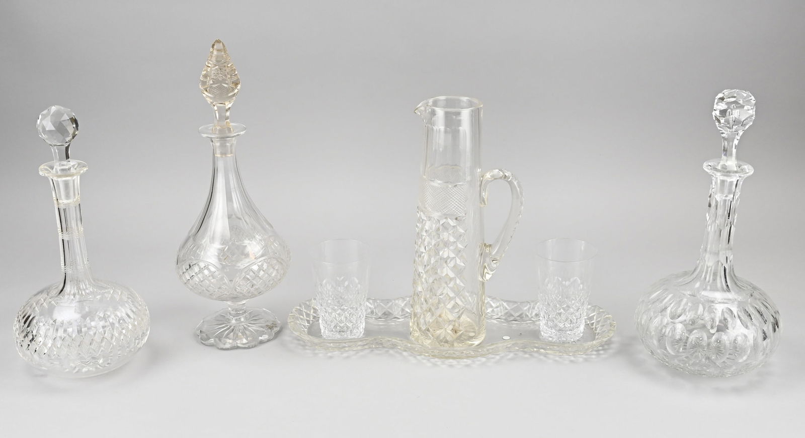 Lot of various glassware: Lot of antique cut crystal glass. Consisting of: three carafes + four-piece lemonade set. Size: 10 - 28 cm. In good condition.