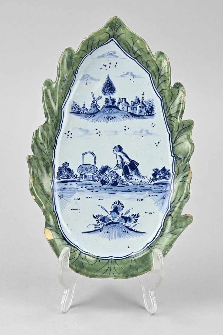 Delft presentation dish: 19th century Delft faience serving dish. Figure in landscape decor. One chip. Size: 23.2 cm. In good condition.
