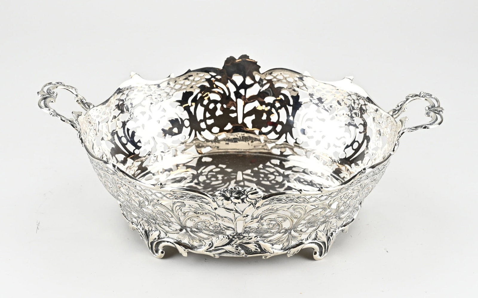 Silver bread basket: Silver bread basket, 835/000, oval sawn model with floral decoration, flowers and engraving. The basket is placed on 4 curled legs and has 2 curled handles. Amsterdam, jl.:k: 1970. 32x22x11cm.
