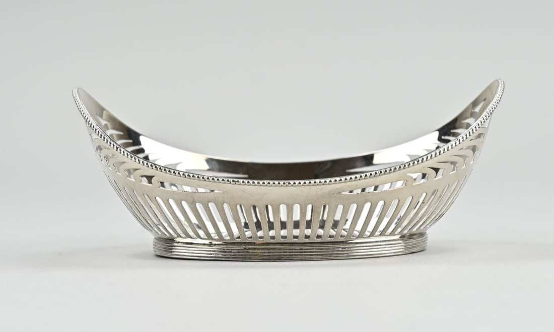 Silver candy basket oval: Silver bonbon basket, 833/000, oval sawn model with bar decoration and decorated with a pearl rim. MT.: G.Reijnen, Schoonhoven, jl.: L: 1921. 13.5x9x5.5cm. approx. 90 grams. In good condition.