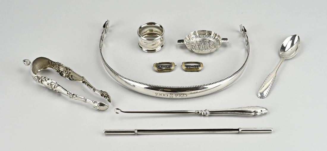 Various silver, 8 x: Lot various with silver; including a handle with pearl rim, a napkin ring with pearl rim, Danish pap spoon with worked handle, a worked lump tongs, a small oval ashtray, 2 gilded calf buckles, a