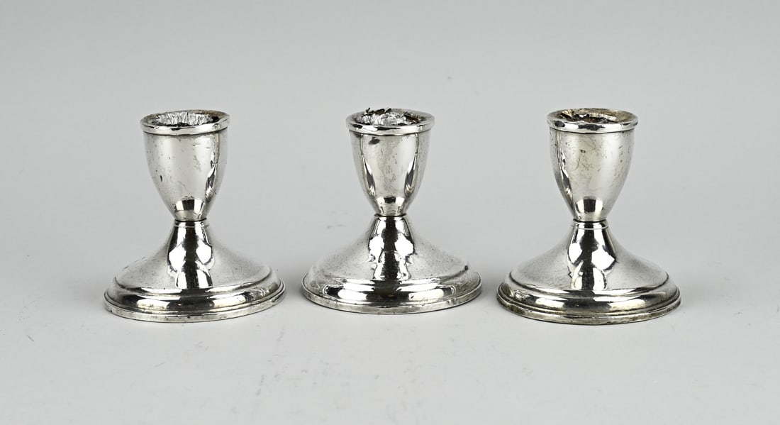 3 Silver candlesticks: Three silver candlesticks, 925/000, on a round base with fillet edges. ø8.5x9cm. Total approx. 591 grams, with filled base. Slightly out of shape, slightly dented base and traces of use.