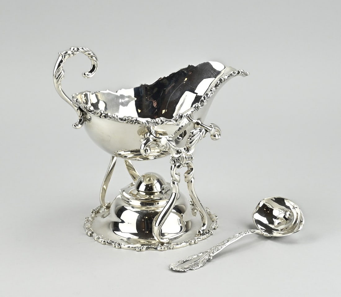 Silver saucer on burner: Silver sauciere on burner with spoon, 925/000, Mexican silver. Sauciere with holder provided with a burner and a sauce spoon, decorated with a soldered floral edge. The burner has a dent on the side,