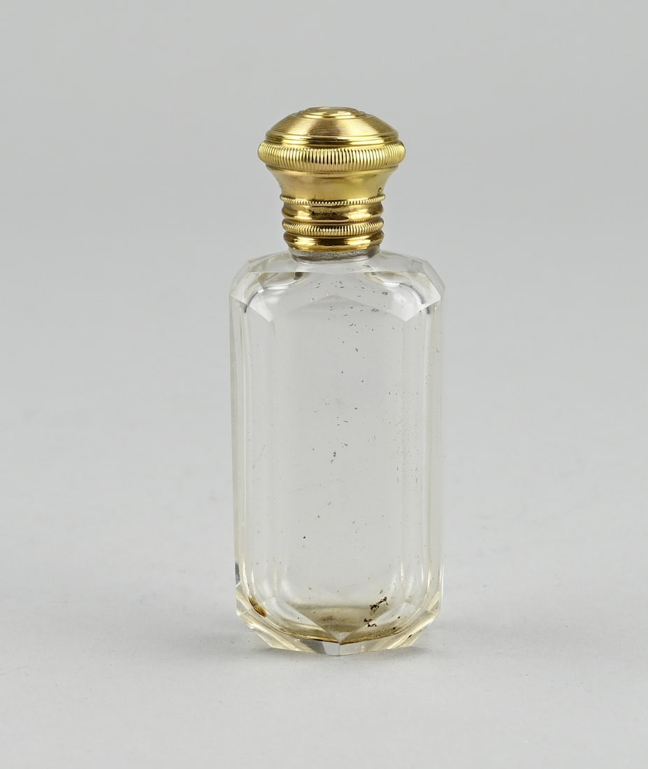 Fragrance bottle with gold: Crystal perfume bottle, rectangular model, with a round yellow gold cap and collar, 750/000, (choose stamp) provided with a cracking edge. 8.2 cm. With inner stopper. Cap slightly dented, otherwise