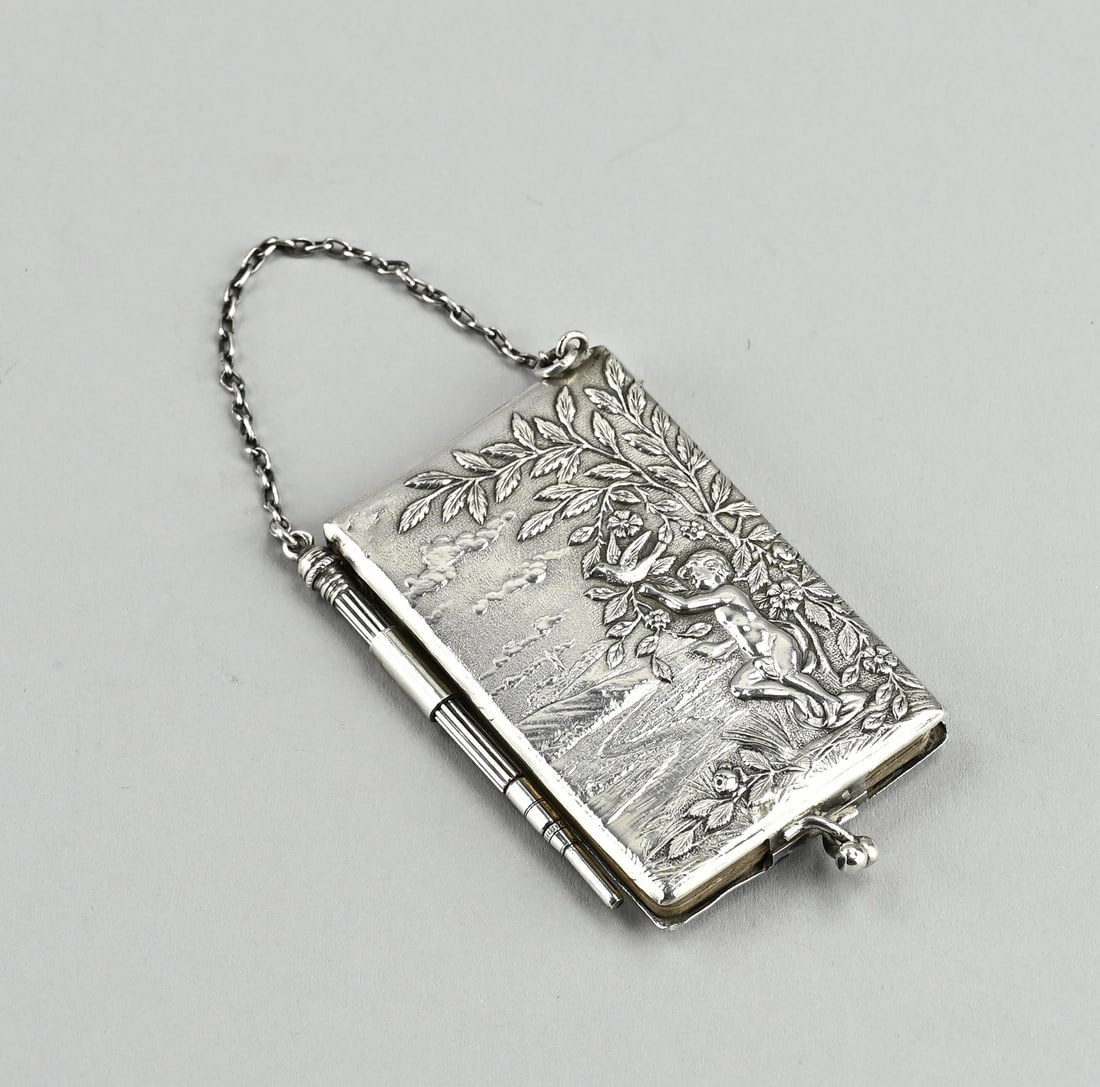 Silver ball book: Silver ball book, 800/000, rectangular model with a representation of putti with bird by a tree. The book has a snap closure and is provided with a pin, attached to the book with a chain. 6x4x0.8 cm.