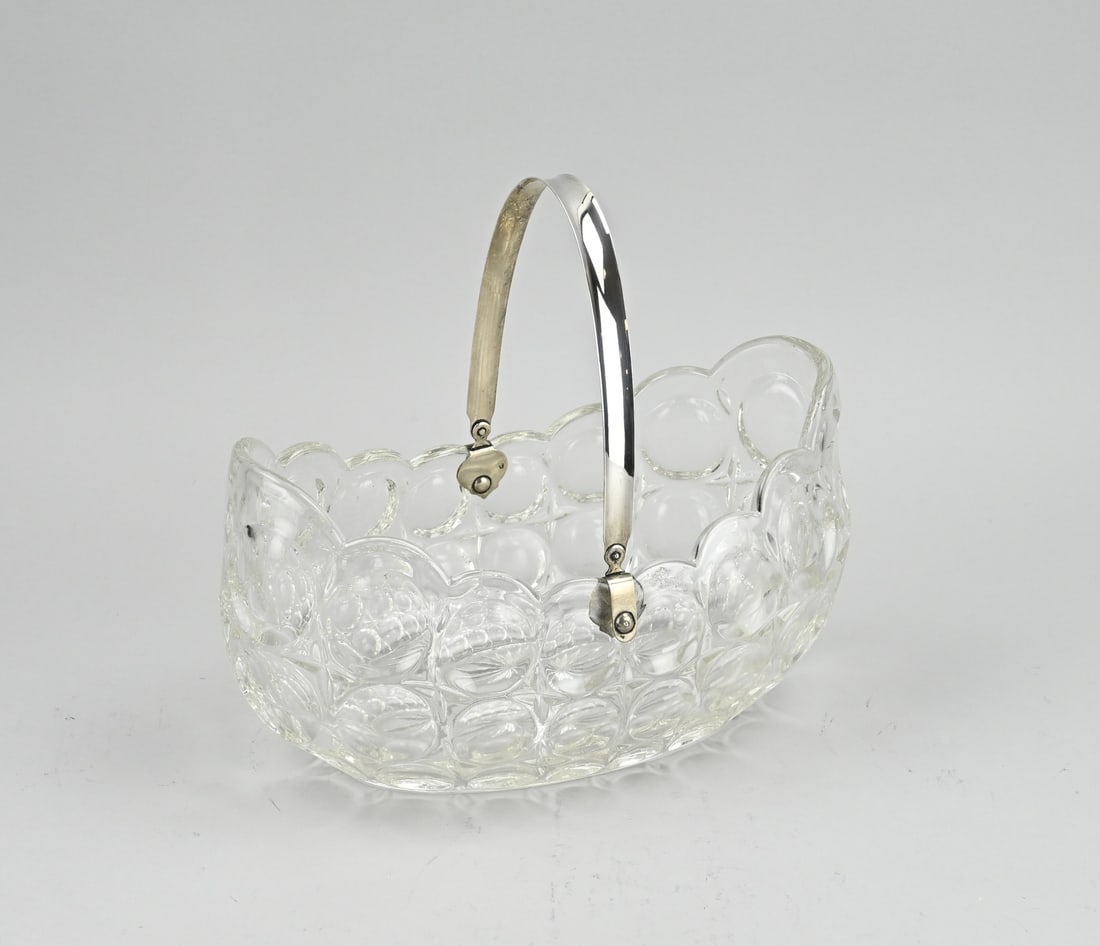 Scale with silver bracket: Deep crystal bowl with silver bracket, 833/000. Oval bowl with scalloped edge and a decoration with balls. The bowl has a smooth silver bracket. MT.: C.Bos and son, Amsterdam, 1929-1947. 25x14x24 cm.