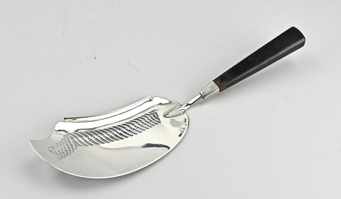 Silver fish spoon: Beautiful fish scoop with a silver scoop, 833/000, contoured model with sawing, attached to an ebony handle. MT.: J.van Wijk, Amsterdam, jl.: X:1832. approx. 140 grams. 35 cm. In good condition.