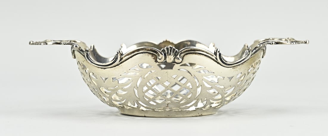 Silver bonbonniere: Silver bonbonniere, 833/000, oval sawn model with pumpkin floral decoration. With a soldered edge with volutes and 2 horizontally placed handles. MT.: Unclear, Schoonhoven, jl.:G:1916. 18x11x4cm.