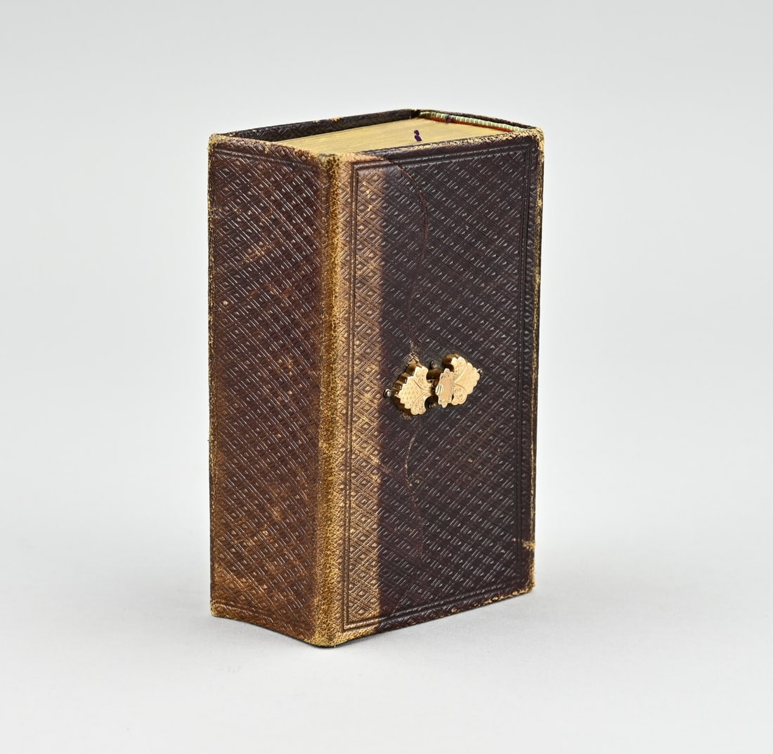 Bible/golden lock: Bible with yellow gold lock, 585/000. Bible the new testament". Bible with a leather cover provided with an arrangement. Provided with a contoured gold lock decorated with engraving. 13.5x9x5 cm.