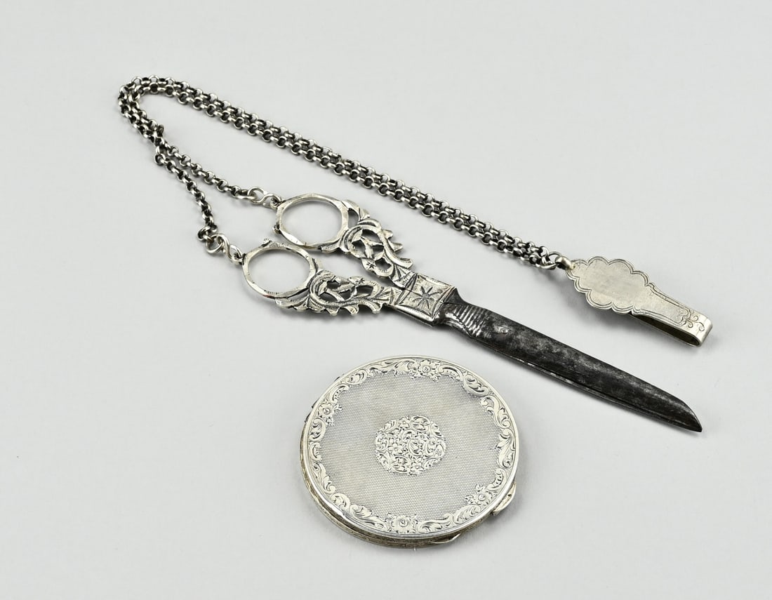Silver powder box & scissors: Silver powder box and scissors. Scissors with silver handles, chain and skirt hook, 833/000. And a powder box, 935/000, round model with engraving. Hinge somewhat crooked. 7.5-53 cm. In reasonably