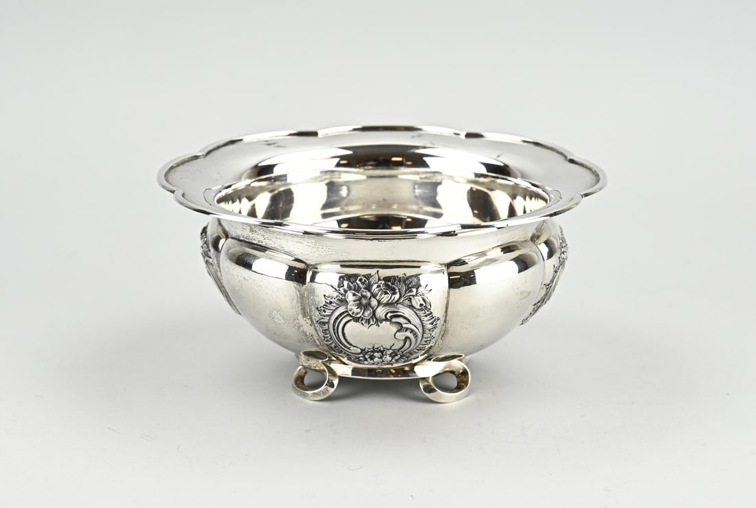 Silver sink bowl: Special silver rinsing bowl, 833/000, round lobed model with a flower-shaped edge and decorated with 4 cartouches with volutes and floral decoration. The bowl is placed on a ring with 4 circles. MT.: