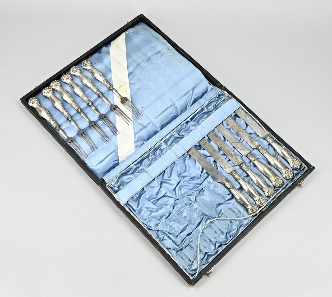 Cassette with 6 forks and knives: Case with 6 forks and knives with silver handle decorated with palmettes and floral decoration. 19 cm. In reasonably good condition.