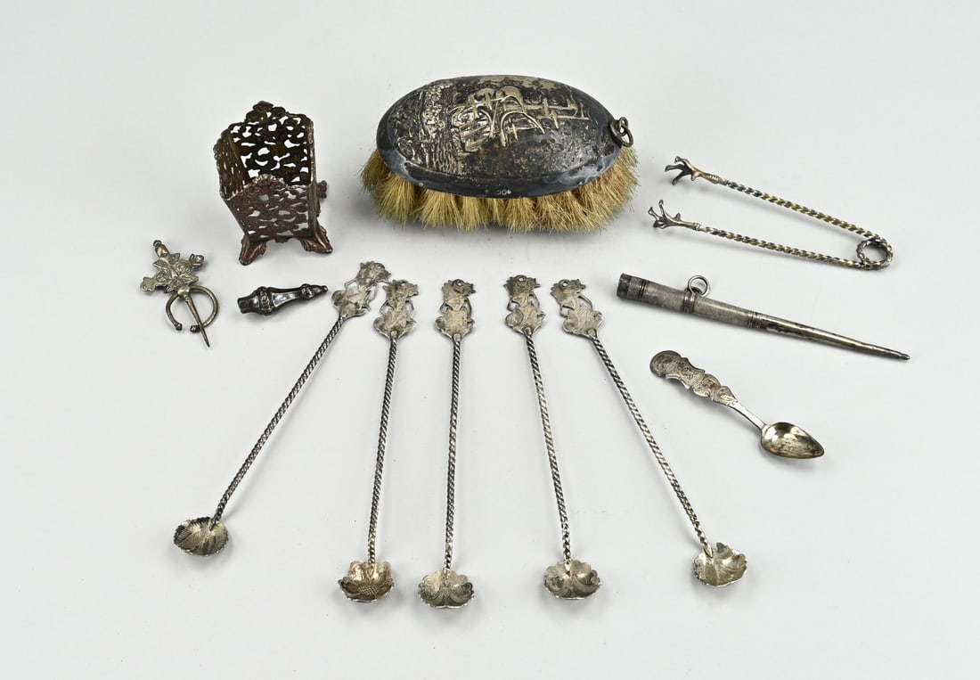 Lot of various silver: Lot of various silver with an oval brush with silver, decorated with a ship, a maggi holder with openwork Biedermeier decoration, 2 different knitting caps, a teaspoon and a lump tongs with claws.