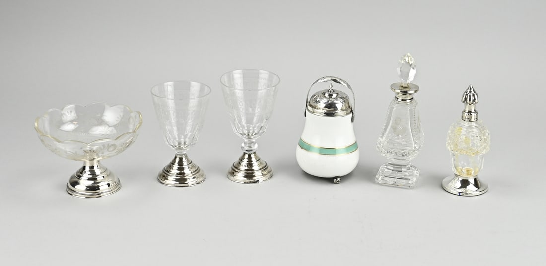 6 Parts diverse with silver: Six pieces with silver, 833/000 including a match pot with silver lid and bracket, engraved 1838, 12 cm. a small carafe with a rectangular shape with grinding and a silver collar. 15 cm. an odor