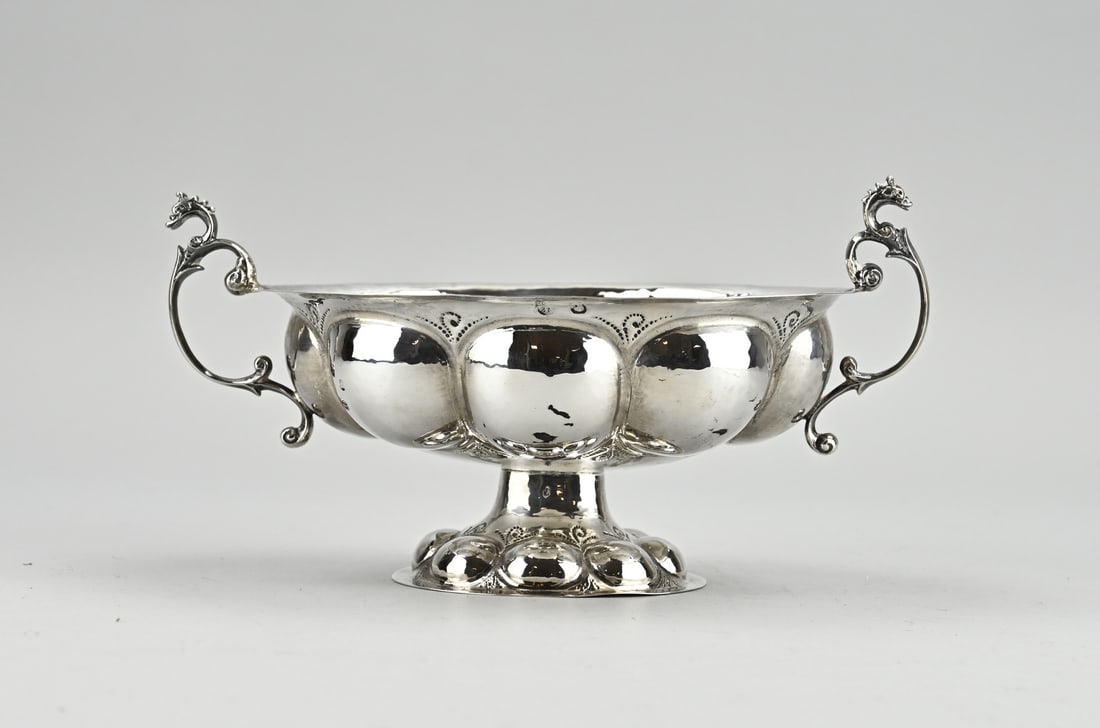 Silver brandy bowl: Antique silver brandy bowl, oval model decorated with chased lobes and pointillist floral decoration. Provided with 2 handles with dragon heads. 18th century. approx. 266 grams. 23x14x12cm. In good
