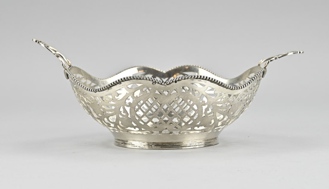 Silver choux pastry basket: Silver choux basket, 835/000, round contoured sawn model with sawn decoration. With a scalloped edge with pearl work and 2 handles with curls and palmette. The basket is placed on a round ring with