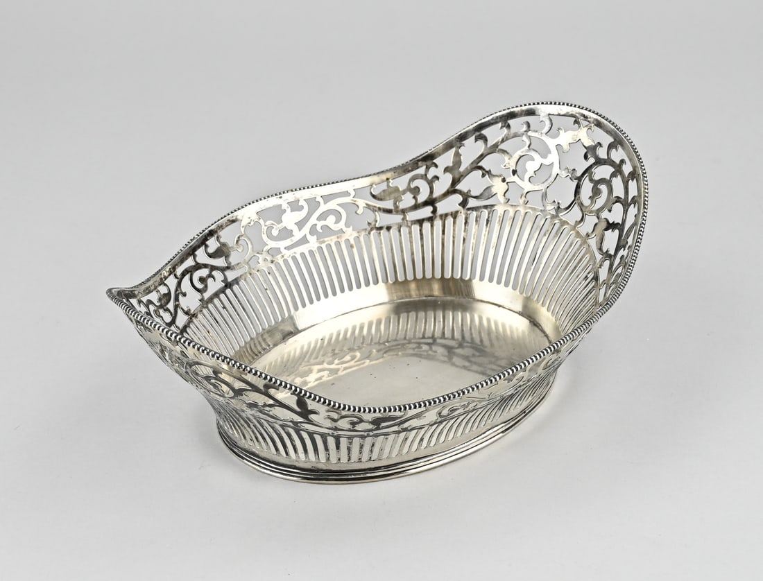 Silver bread basket: Silver bread basket, 833/000, oval sawn model with a contoured edge with pearl decoration. The basket has bars and floral patterns and is placed on an oval edge with filet decoration. Importer's