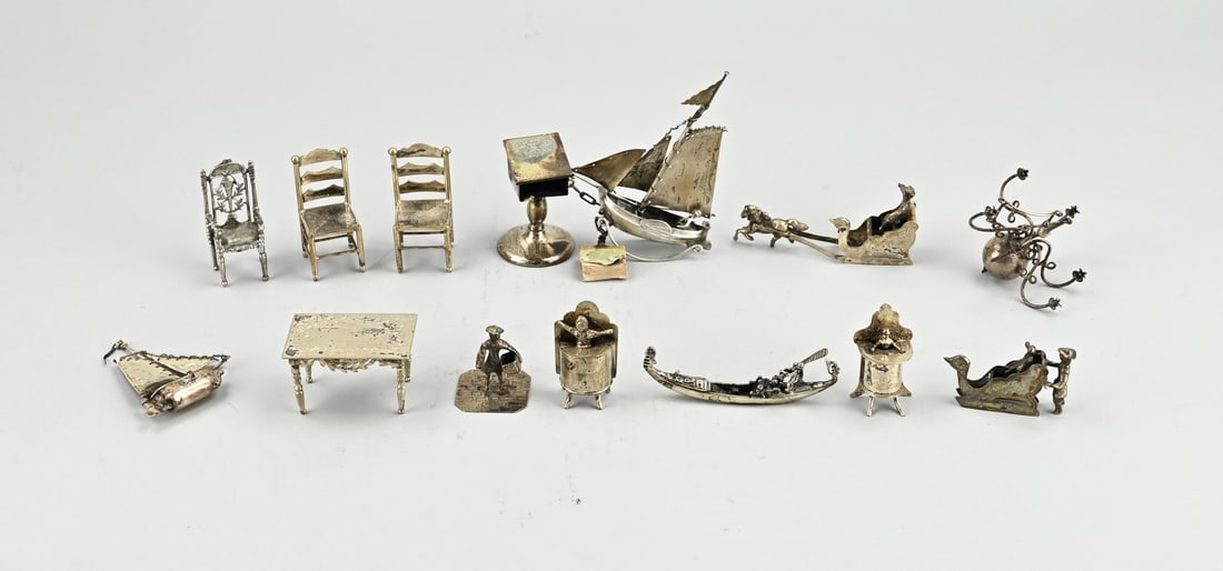 Silver miniatures: Lot with 14 silver miniatures with 3 chairs and a table, 2 sleighs, 2 sailing ships, a gondola, a chandelier, 2 children in a high chair, a desk with a book and a mason. 3-10 cm. approx. 277 grams.