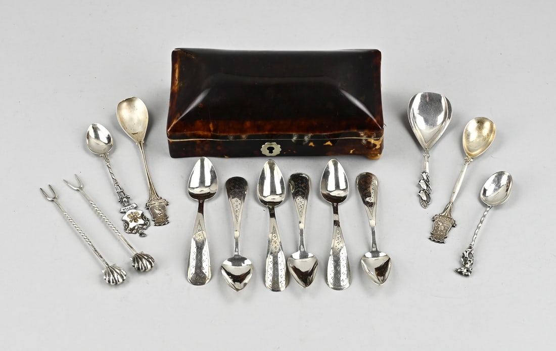 Box with silver spoons: spoon box filled with various silver teaspoons and sugar scoop. approx. 87 grams. And 2 sour picks. Small dent in the lid. 15x8x5