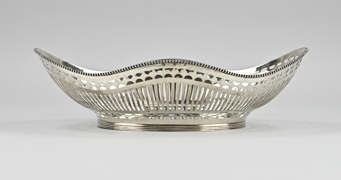 Silver bread basket: Silver bread basket, 835/000, oval contoured model with sawn bars decoration and decorated with a pearl edge. The basket is placed on an oval ring with filet edge. MT.: C.Wewer, Schoonhoven,
