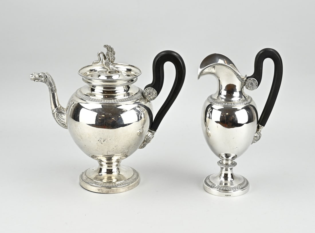 Silver teapot & milk jug: Silver teapot and milk jug, 833/000, on a round base with lambrequin rim. The teapot is decorated with a spout with a dragon's head and acanthus leaves. The wooden handle is attached with a silver