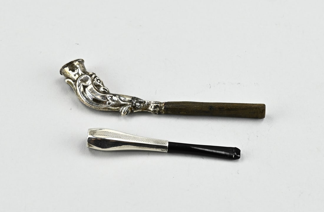 2 Silver cigarette holders: Two silver cigarette holders, 835/000, a hexagonal model with guilloche work, 8 cm. in good condition, and a curved model with work, provided with restoration. Slightly dented. 11.5 cm. In reasonable