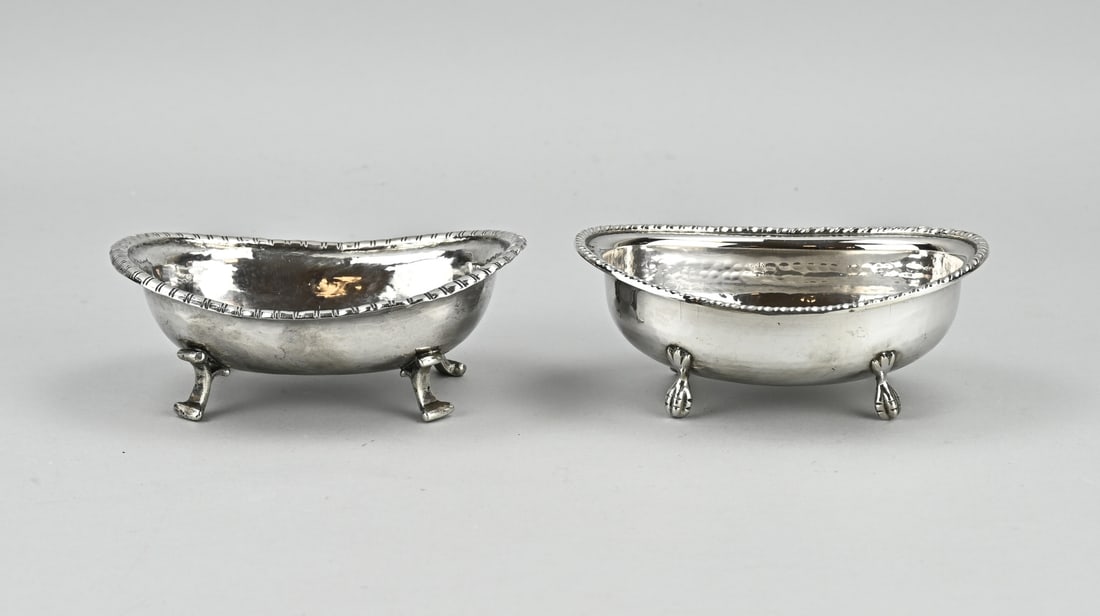 2 Silver bowls: Two silver bowls, oval model with a worked knerren edge. One antique oval bowl placed on 4 curled legs, 14.5x10.5x5.5cm. And an oval bowl with twisted edge placed on 4 claw feet. 14x10x5.5cm. total