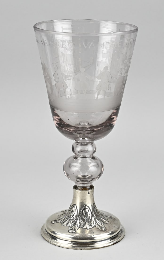 Goblet on silver base: Beautiful 18th century goblet with an etched representation and text: T. wel vaaren van de negotsy. Placed on a silver round foot, 833/000, with acanthus leaves. ø 13x27 cm. In good condition.