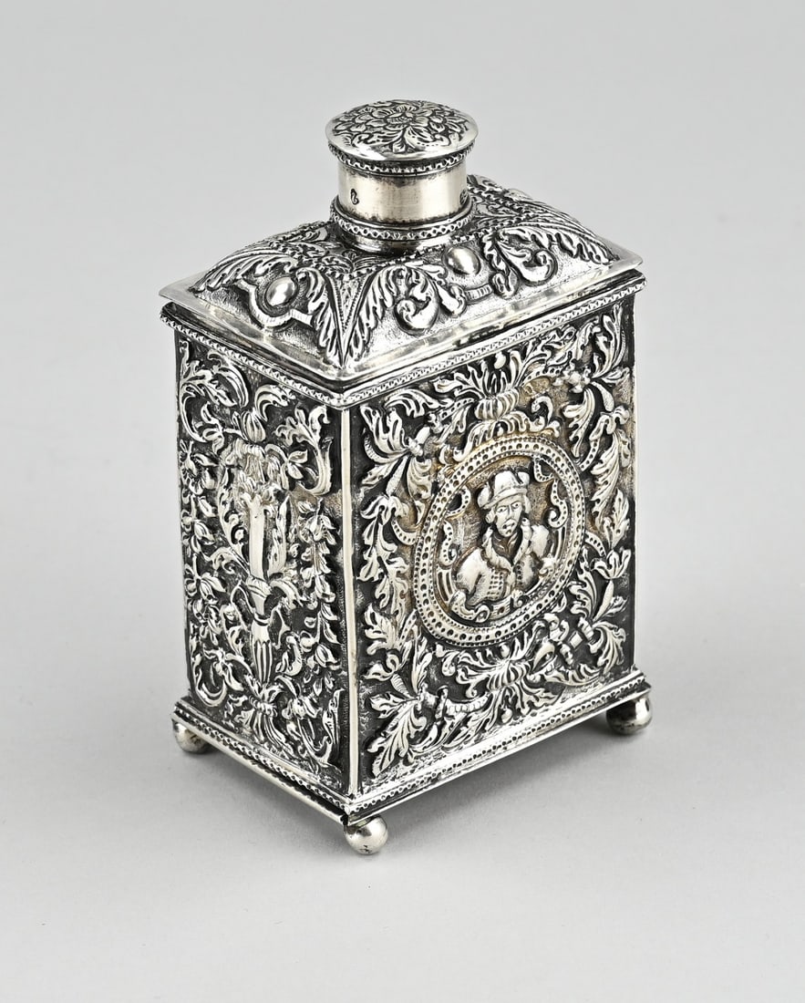 Silver tea caddy with pull-out bottom: Frisian silver tea caddy, rectangular model, beautifully decorated with chased work with floral decoration and a medallion with portrait. Placed on 4 ball feet with a sliding bottom. 7.5x5x13cm.