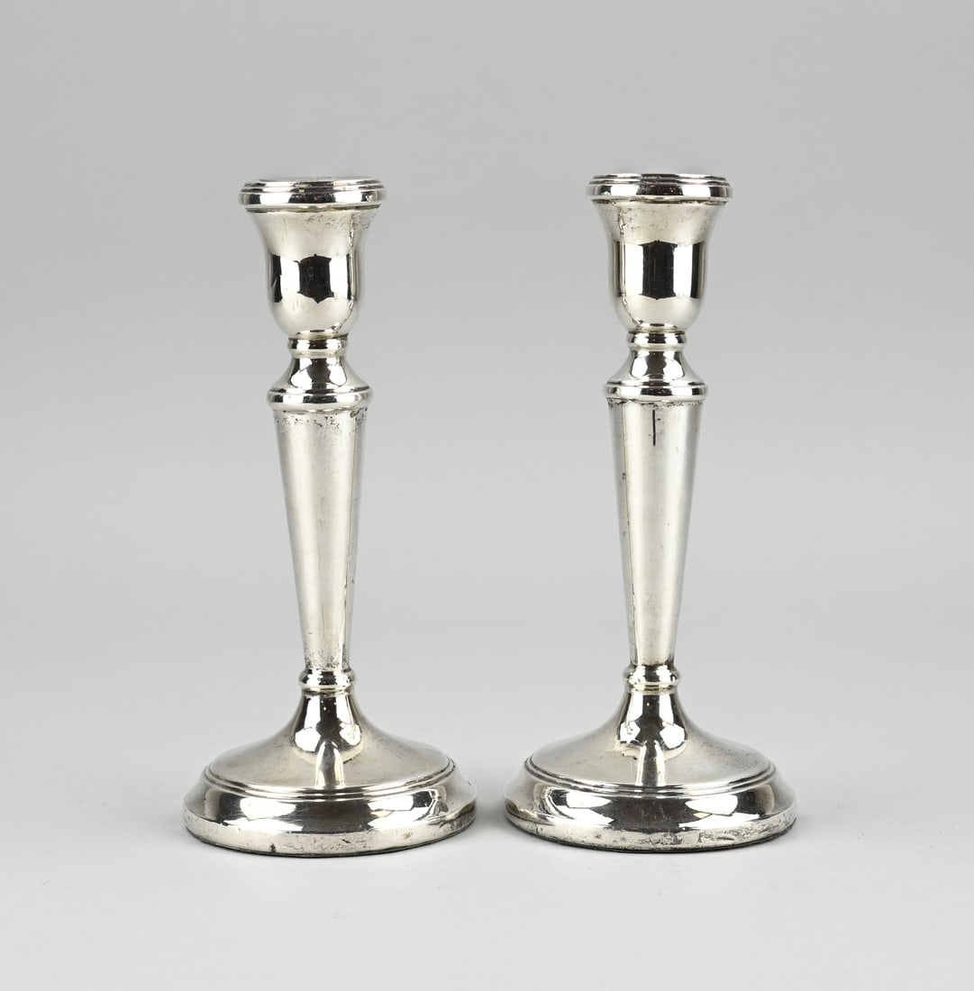 2 Silver candlesticks: Two silver candlesticks, 925/000, on round base. Importer's mark:Esmann juweliers bv, jl.:Q:2000. Slightly dented at the base and baluster. ø8.5x19cm. approx. 487 grams, with filled base. In