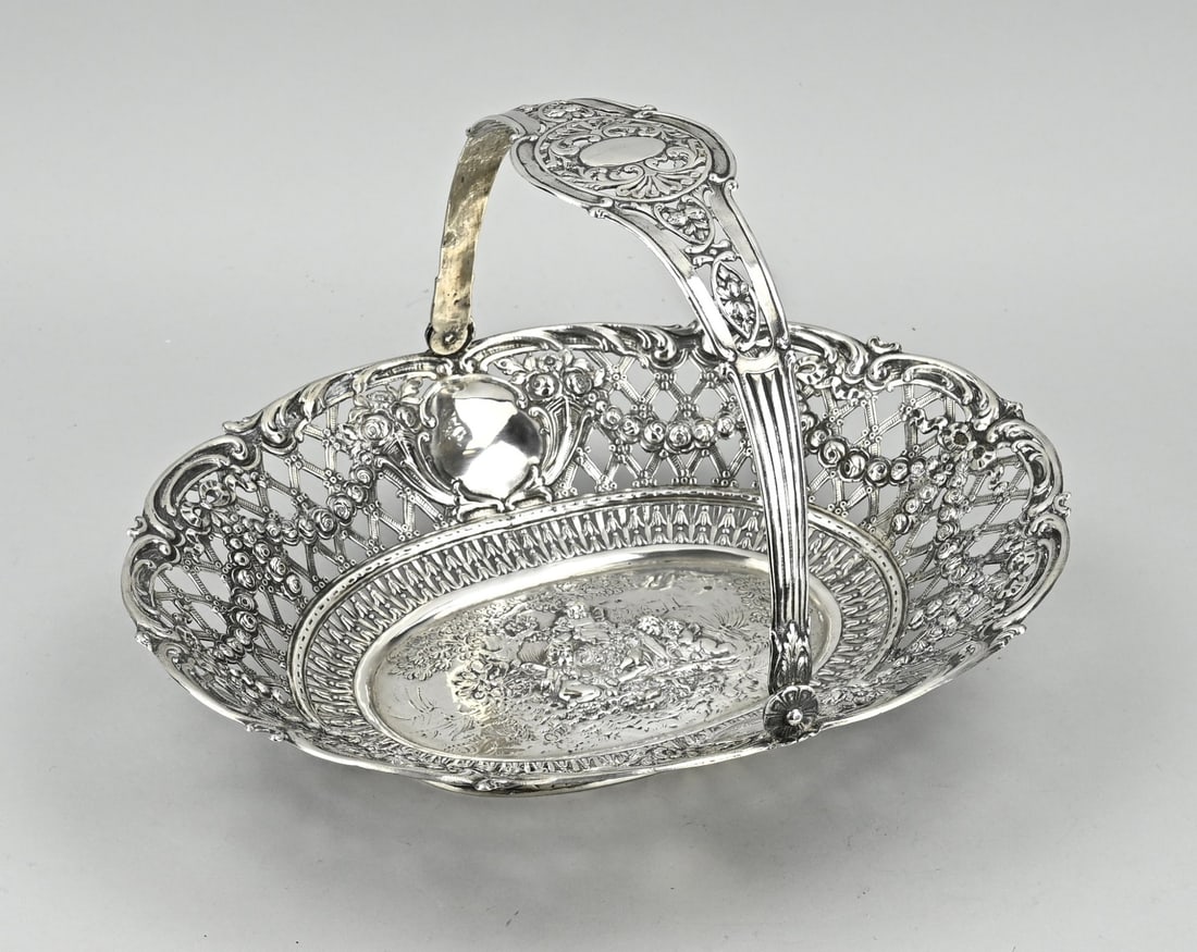 Silver bowl: German silver handle bowl, 800/000. Oval openwork bowl with grid decoration, garlands, bows and cartouches. On the bottom of the bowl is a chased representation with putti. The bowl is provided with