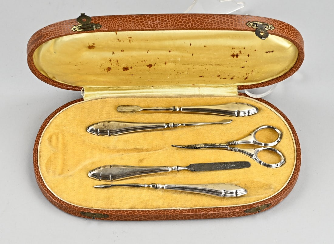 Cassette with silver nail set (manicure): Cassette with silver manicure set, 835/000. Cassette filled with scissors, file, and 3 cuticle accessories, all with a silver contoured handle. 13.5x24cm. In reasonably good condition.
