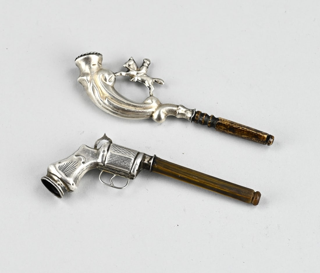 2 Silver Groom Pipes: Two silver groom's pipes, 833/000, one with a representation of a rider on horseback and one in the shape of a revolver. 11-11.5 cm. Minimal dents, otherwise in good condition.