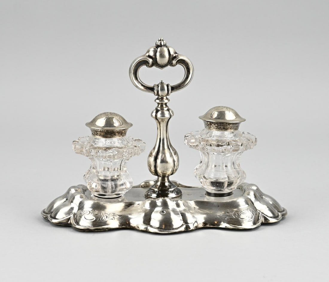 Silver inkstand: Silver inkstand with crystal, 833/000. Inkstand placed on an oval contoured base with handle and provided with 2 cut crystal pots with a silver cap. The inkstand is decorated with engraving. MT.: JM