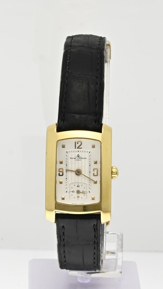 Gold Baume Mercier watch: Beautiful yellow gold Baume Mercier watch, Lady, Hampton, 750/000, with a rectangular case with a decorated dial with an off-center second hand. Quartz. The watch has a leather strap with double