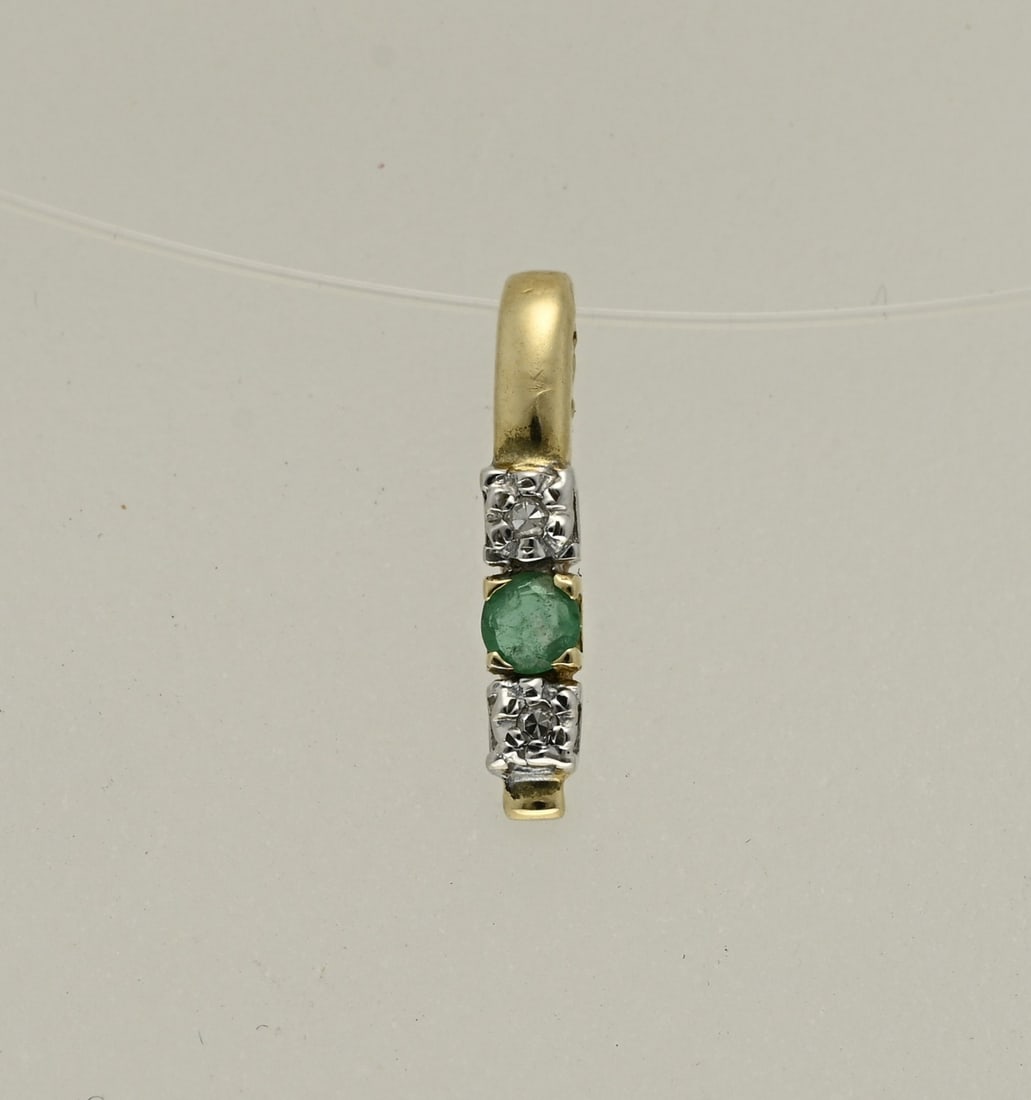 Gold pendant with diamond and emerald: Yellow gold pendant, 585/000, with diamond and emerald. Bar pendant with a row set with 1 round faceted emerald and 2 bezels with a white gold element set with 2 small diamonds. 2.5x14 mm. including