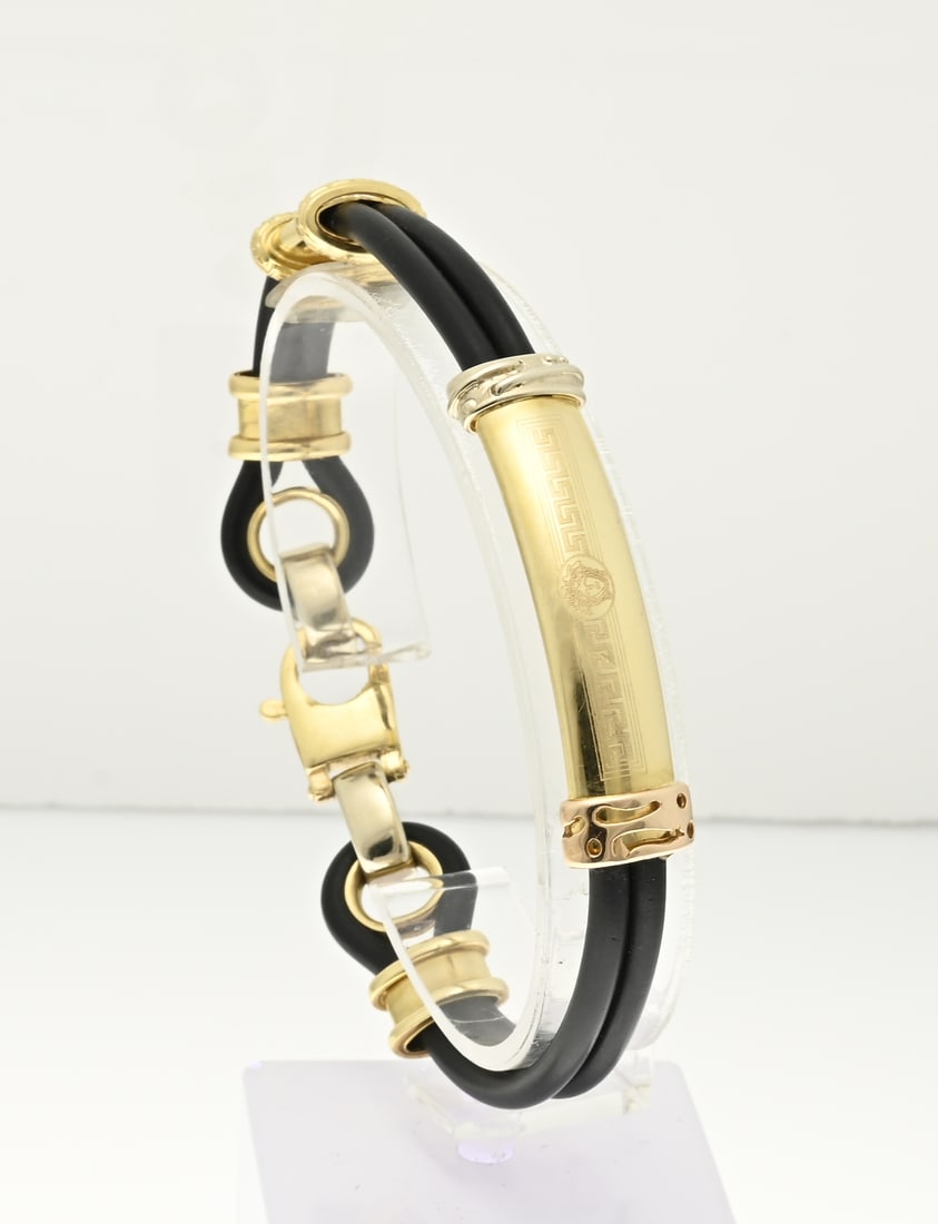 Bracelet with gold and rubber, medusa versace motif: Bracelet with rubber and gold elements, 585/000, an element with Medusa Versace element and a center plate with engraved medusa and meander pattern. approx. 20.1 grams. In good condition.