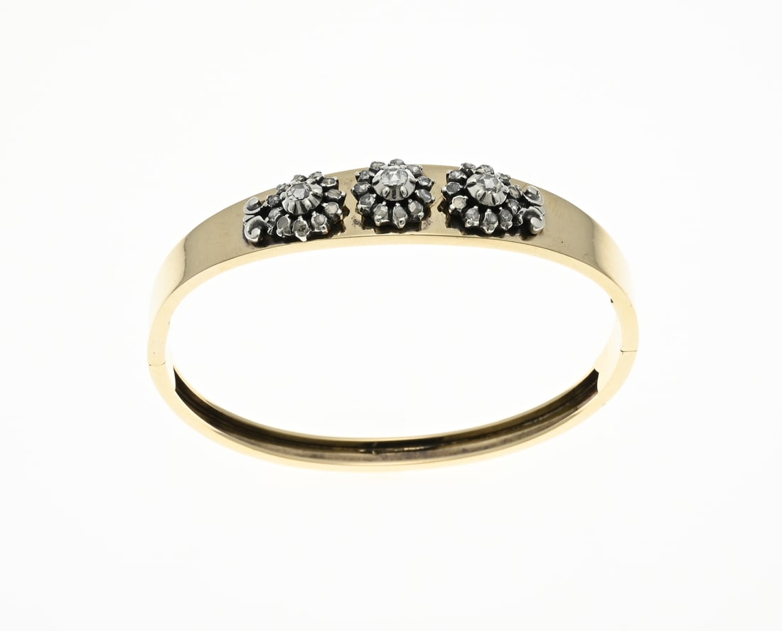 Gold bracelet with rose diamonds: Beautiful yellow gold bangle, 585/000, tapering in width with 3 silver rosettes set with rose-cut diamonds at the top. Bracelet with a hinge and box clasp. Width 5-12.5 mm. Size 59x52.5mm. approx.