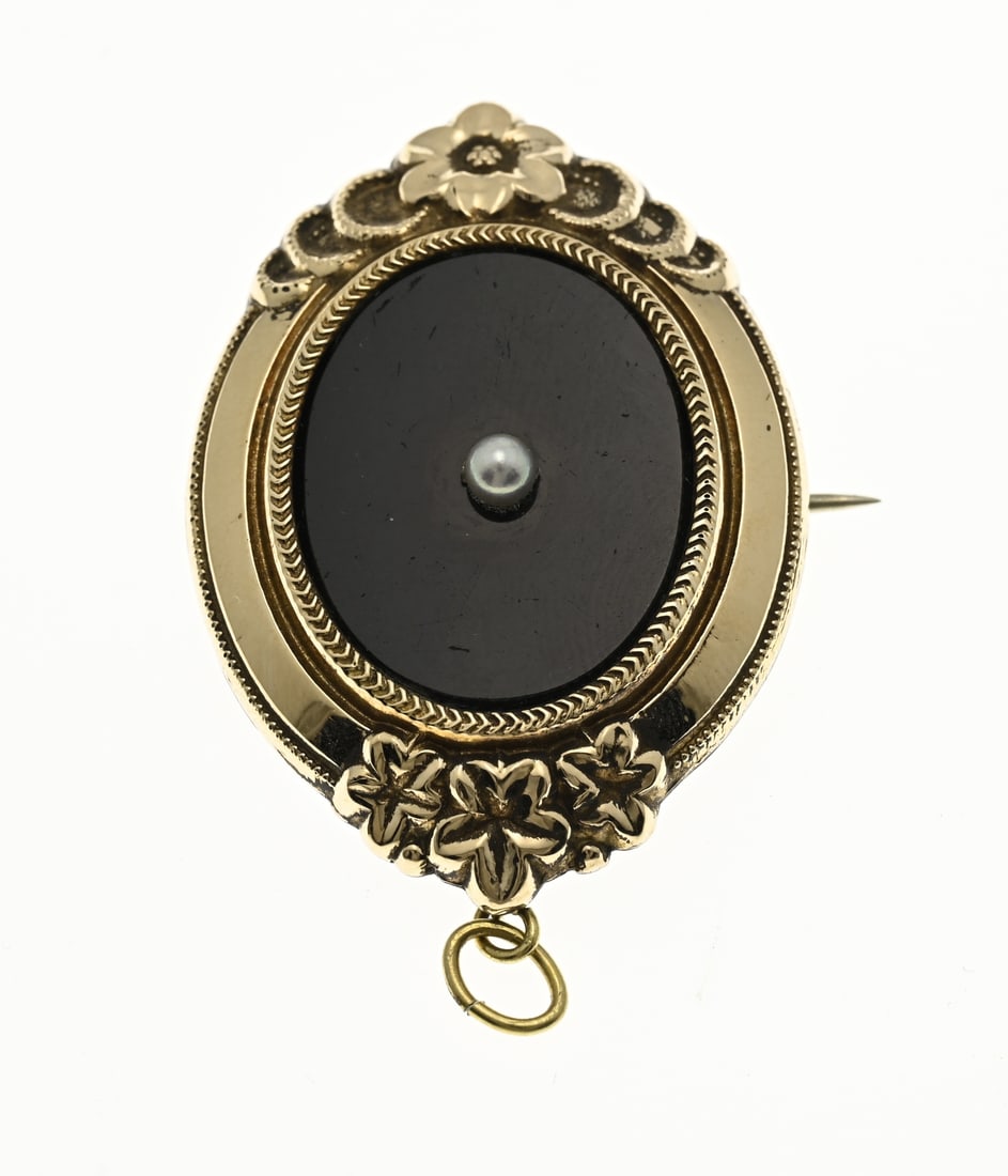 Golden shield brooch with onyx: Shield brooch with gold, 585/000. Oval brooch with an oval yellow gold front with floral elements set with an oval onyx with pearl. And a white metal back. 4.5x3cm. In good condition.
