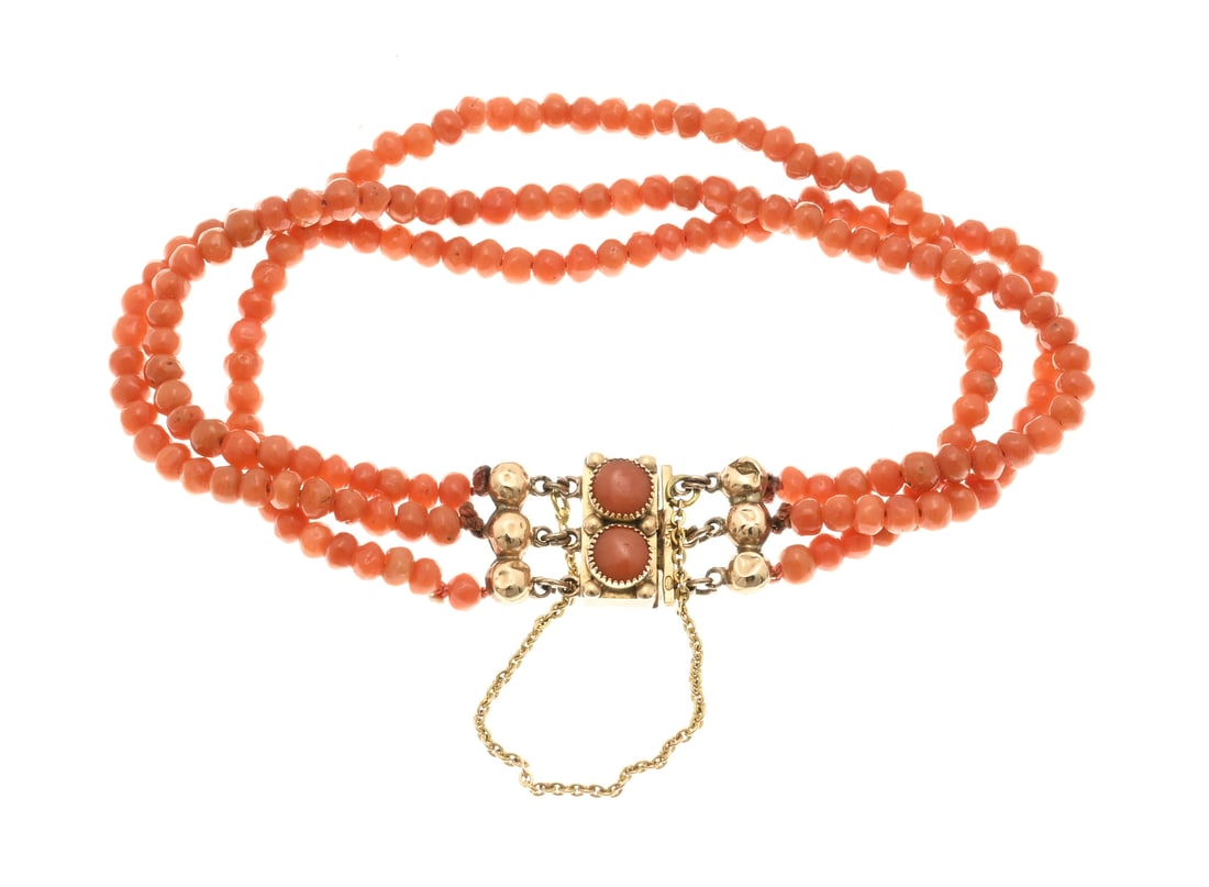 Bracelet with 3 rows of fine blood coral: Bracelet with 3 rows of blood corals, round cut, ø 3.5 mm., attached to a rectangular yellow gold clasp, 585/000, decorated with 2 round blood corals and provided with end pieces and a safety. 18