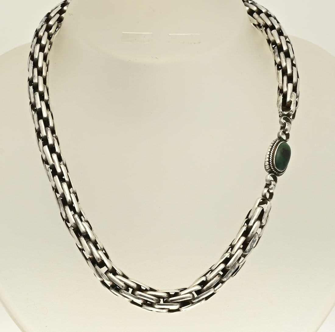 Silver necklace: Long silver necklace, 800/000, with a crocketed links, ø 9 mm. with an oval element with green and red stone. Length 70 cm. approx. 103 grams. In good condition.