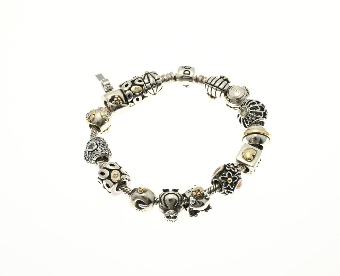 Pandora bracelet with gold charms: Silver Pandora bracelet, 925/000, with Pandora lock and with 15 Pandora charms of which 13 charms with gold elements. Length 18 cm. approx. 68 grams. In very good condition.