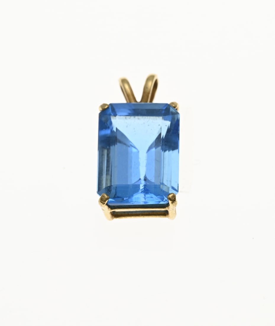 Golden pendant blue stone: Yellow gold pendant, 585/000, with a blue stone. Pendant with a rectangular faceted blue stone. Size pendant 10x20mm. approx. 3 grams. In good condition.