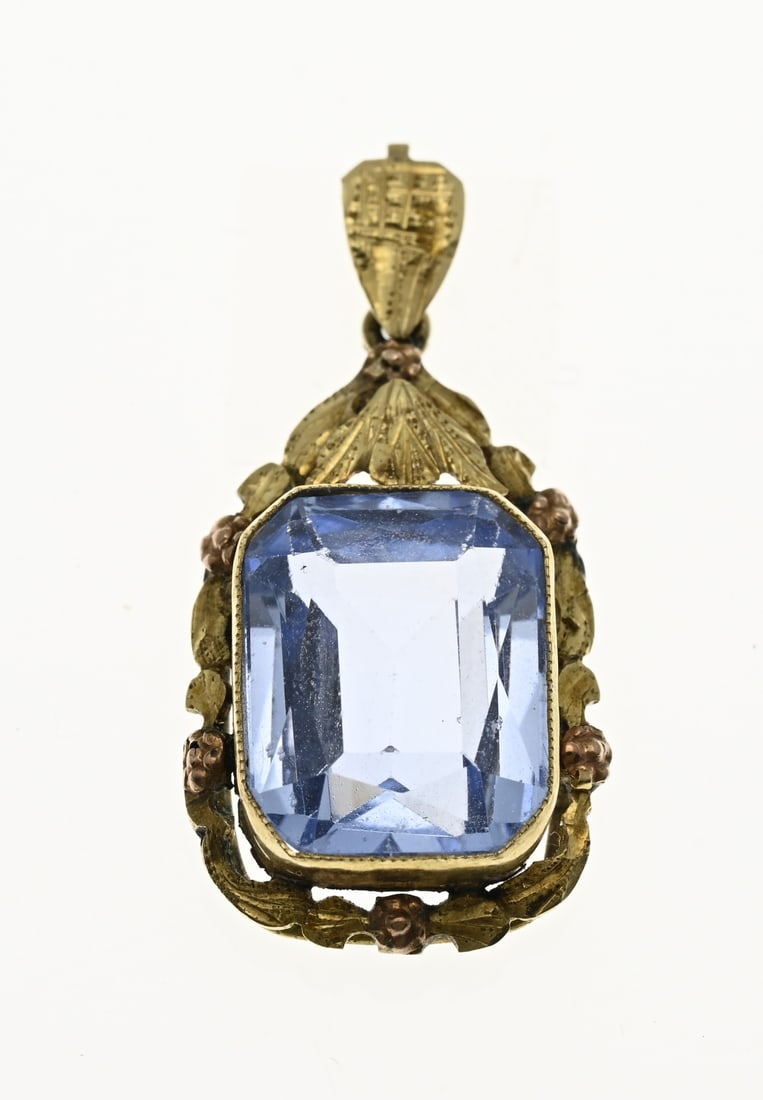 Gold pendant with blue stone: Yellow gold pendant, 585/000, with blue stone. Pendant with a worked yellow gold setting edge decorated with floral elements and small rose-colored flowers. The pendant is provided with a blue faceted