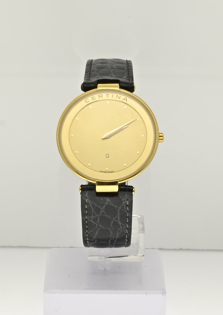 Certina watch, unisex: Certina watch, fitted with round steel plated case, with a gold-coloured dial. The watch has a black leather strap. With sapphire glass. ø case 32 mm. Quartz. 203 1004 26. In box. In very good