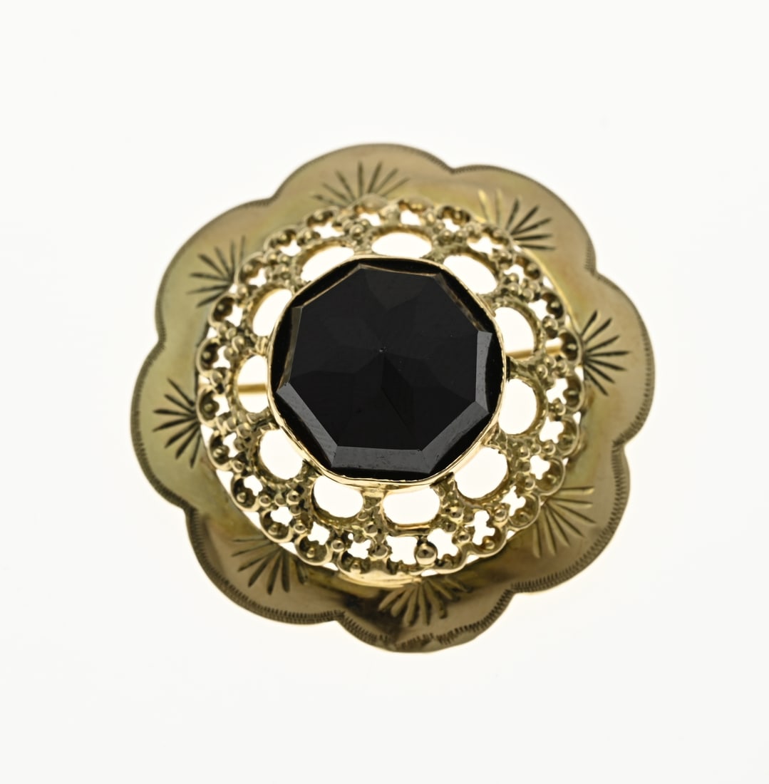 Golden garnet brooch: Yellow gold brooch, 585/000, with garnet. A flower-shaped brooch, openwork with a garnet stone in the middle. ø 29.5mm. approx. 6.5 grams. In very good condition.